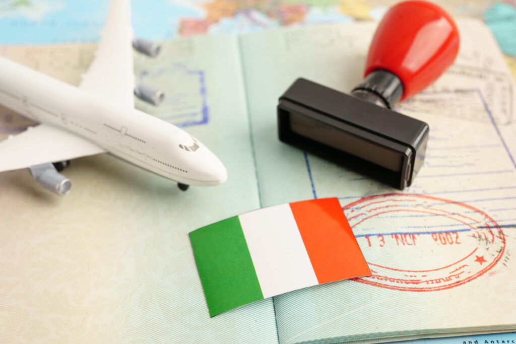 Italy work permit from India process illustrated with visa stamp, flight travel, and Italian flag background