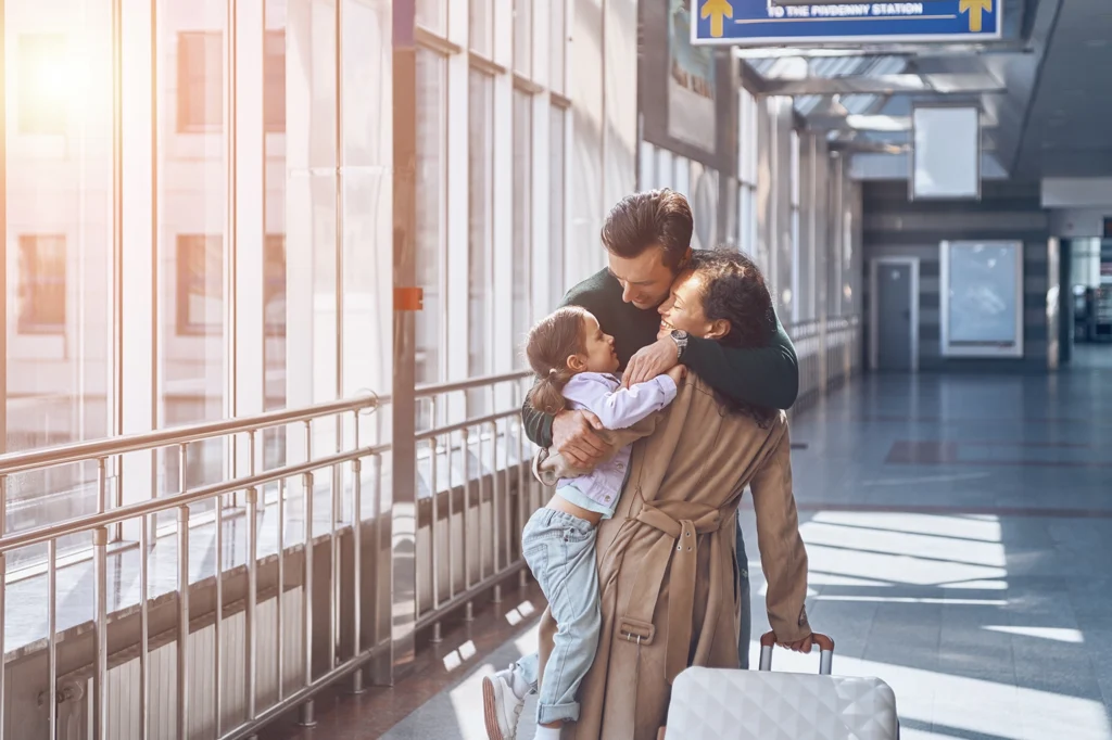 Family reunification visa process emotional moment showing parents hugging their child at the airport after legally bringing spouse and children abroad.