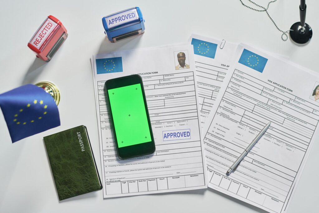 Visa application paperwork with passport, approved stamps, and documents illustrating preparation and documentation required for the UAE work permit from India.